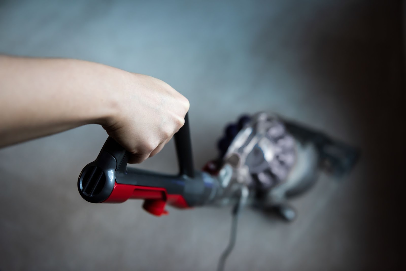 Photo of a hand running a handheld vacuum