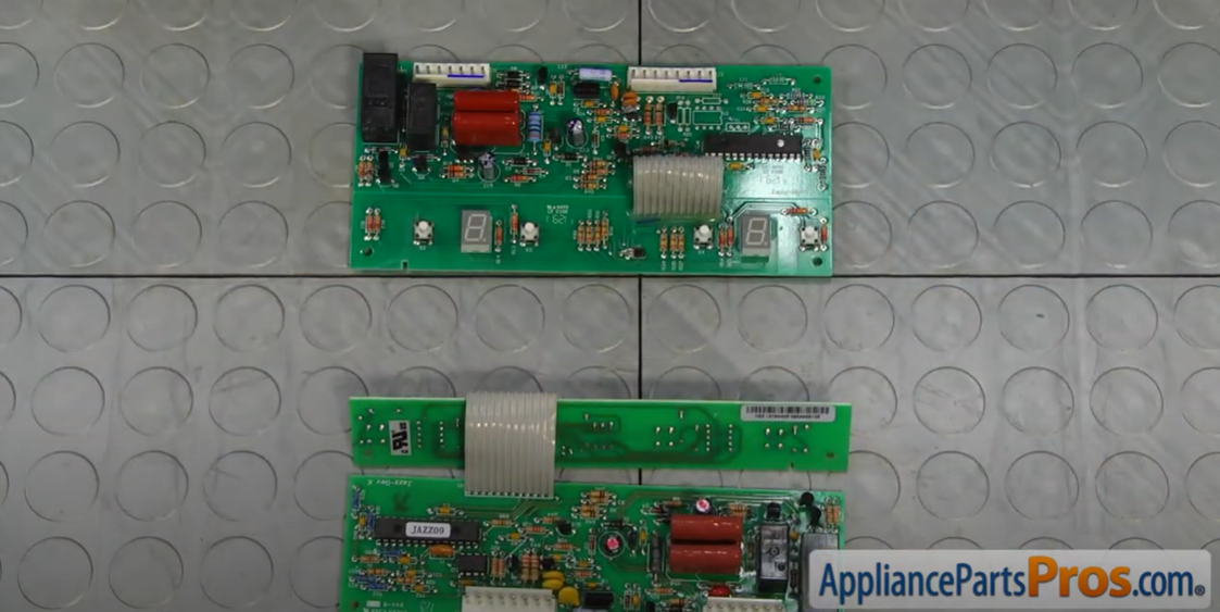 Two refrigerator temperature control circuit boards laid side by side on a gray mat