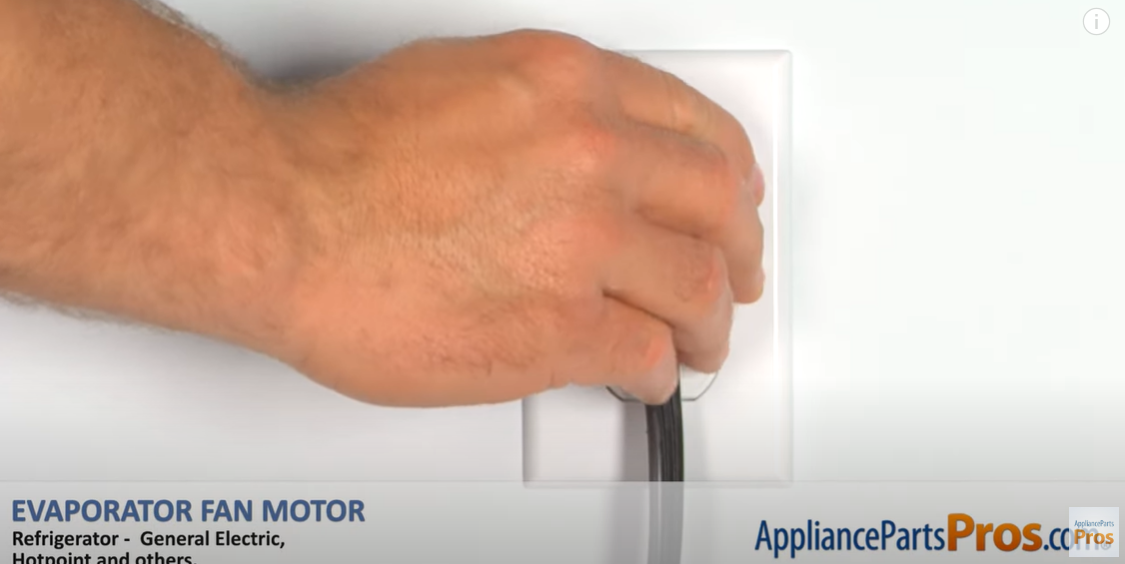 Hand plugging a refrigerator power cord into a wall outlet to restore power after the fan repair