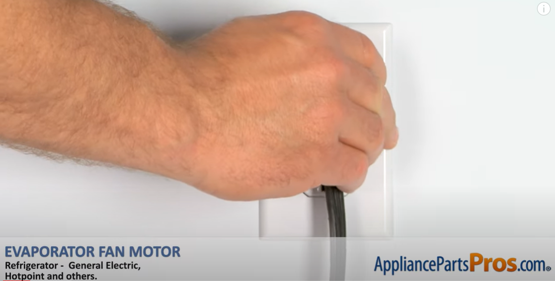 Hand unplugging a refrigerator power cord from a wall outlet before starting repairs