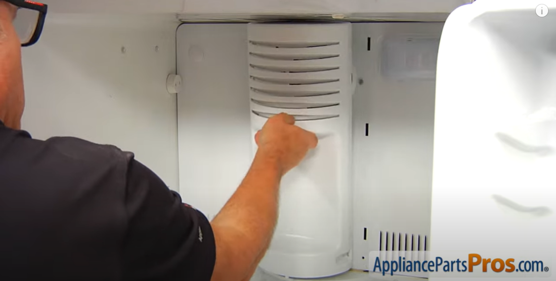 Technician pulling off the vented evaporator cover inside a freezer