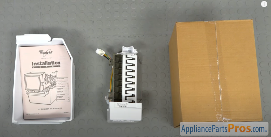 Ice maker kit laid out with its Whirlpool installation manual, ice maker assembly, and shipping box