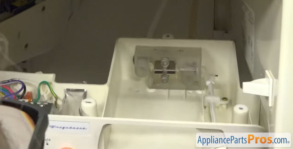 Refrigerator control housing lowered from the ceiling, showing wires and the thermostat inside